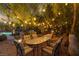 Al fresco dining area under mature trees and string lights overlooking pool and spa, perfect for outdoor entertaining at 9 Chalet Hills Ter, Henderson, NV 89052