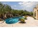 Stunning pool area featuring a rock waterfall, lush landscaping, and ample space for relaxation and outdoor enjoyment at 9 Chalet Hills Ter, Henderson, NV 89052