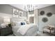 A beautifully staged bedroom features a large bed, modern chandelier, and tasteful wall decor at 96 Via Franello, Henderson, NV 89011