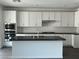 Modern kitchen featuring white cabinets, stainless steel appliances, and a black countertop island at 96 Via Franello, Henderson, NV 89011