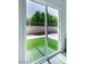 View of backyard with artificial grass and block wall fence seen through sliding glass doors at 9813 Folsom Dr, Las Vegas, NV 89134