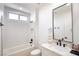 Modern bathroom with white tile, black fixtures, and a marble countertop at 9813 Folsom Dr, Las Vegas, NV 89134