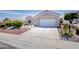 Exterior view of a single-story home with a red tile roof and a two-car garage at 9813 Folsom Dr, Las Vegas, NV 89134