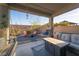 Outdoor patio with fire pit, chairs, bench swing, and string lights at 10031 Fletcher Peak Ave, Las Vegas, NV 89178