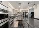 Modern kitchen boasts gray cabinets, dark wood floors, stainless steel appliances, and granite countertops at 10031 Fletcher Peak Ave, Las Vegas, NV 89178