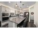 Modern kitchen boasts gray cabinets, dark wood floors, stainless steel appliances, and granite countertops at 10031 Fletcher Peak Ave, Las Vegas, NV 89178