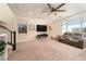 Comfortable living room with a ceiling fan, large windows, and a plush reclining sofa at 10031 Fletcher Peak Ave, Las Vegas, NV 89178