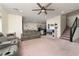Spacious living room with plush carpeting, a comfortable sofa, and staircase access to the upper level at 10031 Fletcher Peak Ave, Las Vegas, NV 89178
