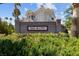 Welcoming entrance to Red Bluffs community featuring lush greenery and mature palm trees at 10116 Jacob Pl # 104, Las Vegas, NV 89144
