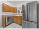 Functional kitchen featuring wood cabinets, stainless steel appliances, and tiled countertops at 10116 Jacob Pl # 104, Las Vegas, NV 89144