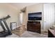 Comfortable bedroom featuring workout equipment, dresser, and mounted TV at 10370 Sweet Laurel St, Las Vegas, NV 89178