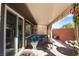 Relaxing covered patio with outdoor seating, brick wall, and privacy curtains with a fountain at 10370 Sweet Laurel St, Las Vegas, NV 89178