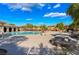 Community pool with lounge chairs and tables, surrounded by lush landscaping in a vibrant setting at 10370 Sweet Laurel St, Las Vegas, NV 89178