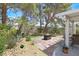 Spacious backyard with a patio, fire pit, mature trees, and drought-tolerant landscaping at 1658 Autumn Rust Dr, Las Vegas, NV 89119