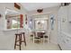 Bright dining nook with a wooden table and chairs set near a bay window, and a breakfast bar area with stool at 1658 Autumn Rust Dr, Las Vegas, NV 89119