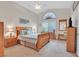 A spacious main bedroom boasts a high ceiling, large window and a plush bed with classic wooden furniture at 1658 Autumn Rust Dr, Las Vegas, NV 89119