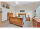 The main bedroom showcases a bed, a ceiling fan and coordinated wooden furniture and a sunlit window at 1658 Autumn Rust Dr, Las Vegas, NV 89119