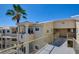 Beige building exterior with multiple stories, walkway, and a palm tree on a sunny day at 1979 Cutlass Dr # 1979, Henderson, NV 89014