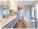 Bathroom with dual vanity, large mirror, and separate bathtub at 4708 Grand Rock Dr, North Las Vegas, NV 89081