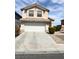 Charming two-story home with a white garage door and desert landscaping at 4708 Grand Rock Dr, North Las Vegas, NV 89081