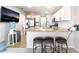 Bright kitchen features stainless steel refrigerator, white cabinetry, granite countertops, and a TV on the wall at 4708 Grand Rock Dr, North Las Vegas, NV 89081