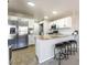 Bright kitchen features stainless steel refrigerator, white cabinetry, and granite countertops with barstool seating at 4708 Grand Rock Dr, North Las Vegas, NV 89081