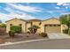 Charming single-story home featuring a tan exterior, manicured landscaping, and a two-car garage at 5300 E La Terra Ave, Pahrump, NV 89061