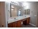 Bathroom featuring double sinks, wood cabinets, expansive mirror, and sleek gray flooring at 6652 Weeping Pine St, Las Vegas, NV 89149