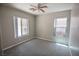 Neutral bedroom with carpeted floor, ceiling fan, and two windows at 6652 Weeping Pine St, Las Vegas, NV 89149