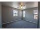 Comfortable carpeted bedroom bathed in natural light from multiple windows, complete with a ceiling fan at 6652 Weeping Pine St, Las Vegas, NV 89149