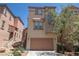 Charming two-story home with a welcoming facade and a convenient attached garage, complemented by blooming plants at 6652 Weeping Pine St, Las Vegas, NV 89149