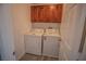 Laundry room features a washer, dryer, overhead cabinets and wood-look floors at 6652 Weeping Pine St, Las Vegas, NV 89149