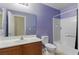 Clean bathroom with purple accent wall features a shower-tub combo and white vanity at 1069 Thrill Ct # 102, Henderson, NV 89002