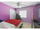 Bedroom featuring purple walls, a bed, dresser, TV, and a window for natural light at 1069 Thrill Ct # 102, Henderson, NV 89002