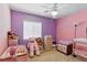 Bright bedroom with pink and purple walls, ceiling fan, and ample space for furniture at 1069 Thrill Ct # 102, Henderson, NV 89002