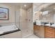 Contemporary bathroom featuring a tub, tiled shower, and a stylish vanity with a large mirror at 135 E Harmon Ave # 2515, Las Vegas, NV 89109