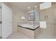 Bright bathroom showcasing a soaking tub, tiled shower, and white door at 135 E Harmon Ave # 2515, Las Vegas, NV 89109