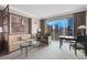 Well-lit living area with a sofa, armchair, coffee table, desk, and city views at 135 E Harmon Ave # 2515, Las Vegas, NV 89109