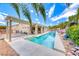 Backyard oasis featuring a pool with clear blue water, covered patio, and lush tropical landscaping at 1862 Redwood Valley St, Henderson, NV 89052