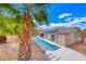 Lush backyard features a long, narrow pool, tropical palm trees, and solar panels on the roof at 1862 Redwood Valley St, Henderson, NV 89052