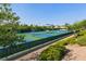 Outdoor tennis courts are surrounded by trees and bushes and are ready for a friendly competition at 1862 Redwood Valley St, Henderson, NV 89052