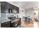 Cozy kitchen featuring modern stainless steel appliances, dark cabinets, and a dining area with seating at 221 Mission Catalina Ln # 104, Las Vegas, NV 89107