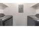This laundry room includes a gray washer and dryer and convenient white shelving at 221 Mission Catalina Ln # 104, Las Vegas, NV 89107