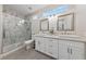 Bright bathroom with a double vanity, decorative mirrors, and a glass-enclosed shower at 2728 Faiss Dr, Las Vegas, NV 89134