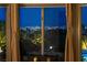 Breathtaking nighttime city view through a large window framed by elegant curtains at 2728 Faiss Dr, Las Vegas, NV 89134