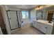 Bright bathroom featuring a glass shower, tub, double vanity with black fixtures, and wood-look flooring at 3339 Cromford Dr, North Las Vegas, NV 89081