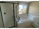 Modern bathroom with sleek black-framed glass shower and separate tub under a bright window at 3339 Cromford Dr, North Las Vegas, NV 89081