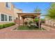 This beautiful backyard features a gazebo with a picnic table, a grill, desert landscaping and shrubs at 4212 Hawks Glide Ave, North Las Vegas, NV 89084