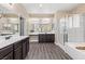 Bright bathroom featuring dual sinks, dark wood cabinets, walk-in shower and soaking tub at 4212 Hawks Glide Ave, North Las Vegas, NV 89084