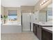 Bright bathroom features a tub under a window, a glass shower and a vanity with neutral colored walls at 4212 Hawks Glide Ave, North Las Vegas, NV 89084